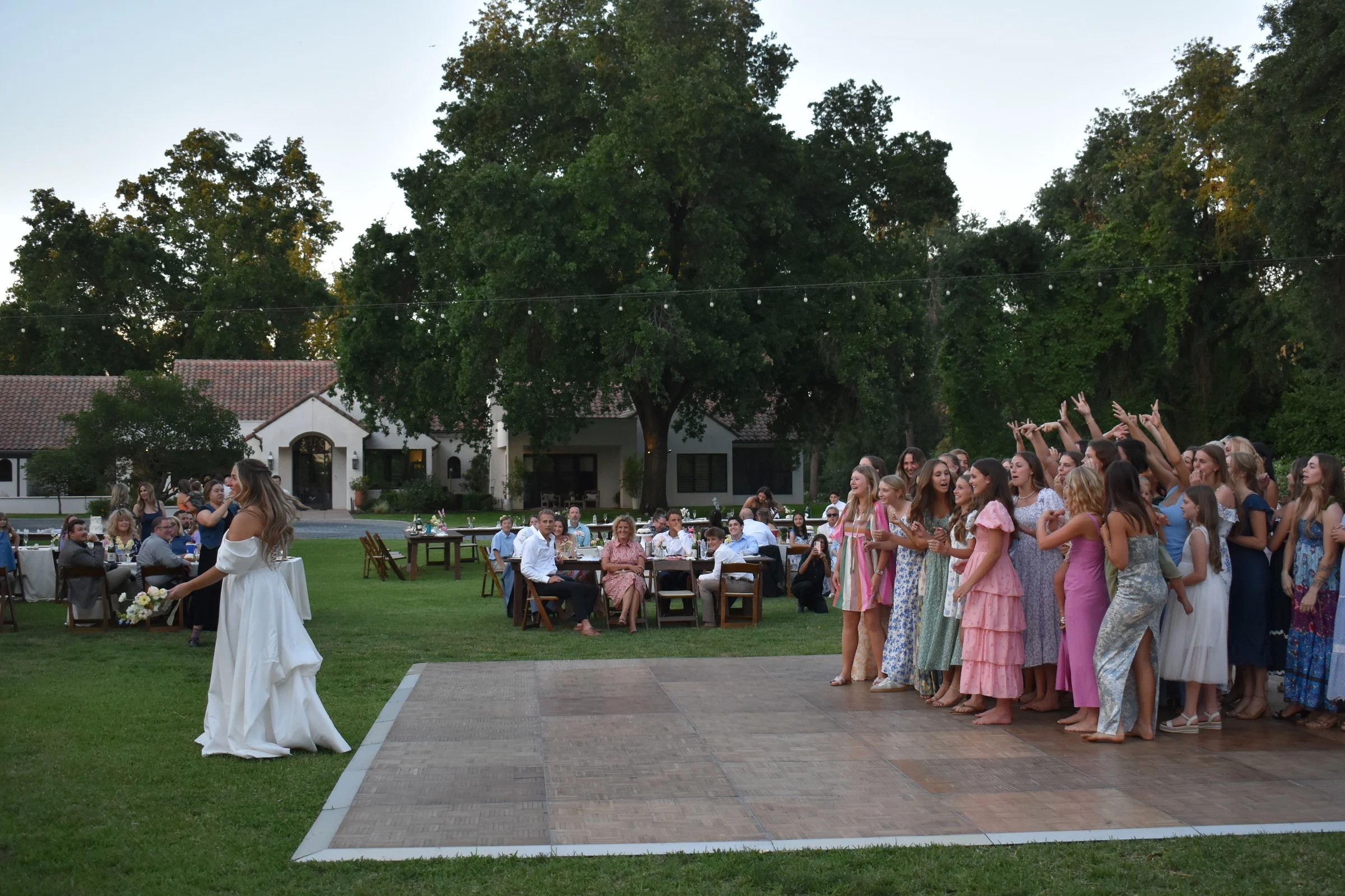 Bouquet toss at outdoor wedding reception celebration